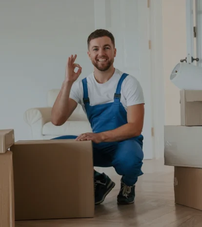 ein glücklicher Mitarbeiter einer Umzugsfirma, der in die Kamera schaut