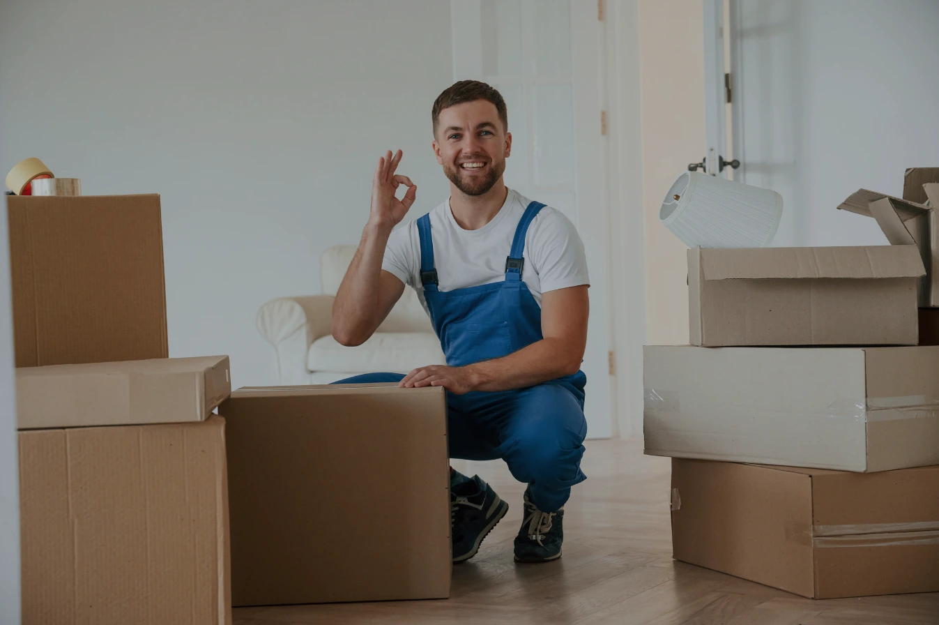 ein glücklicher Mitarbeiter einer Umzugsfirma, der in die Kamera schaut