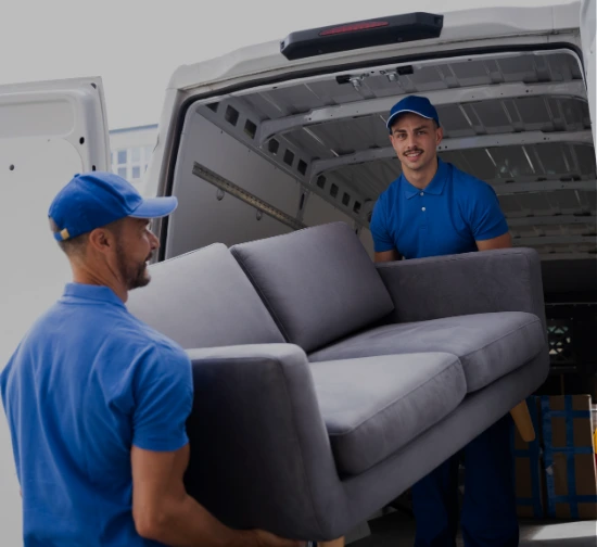 two workers uploading a sofa to a cargo van